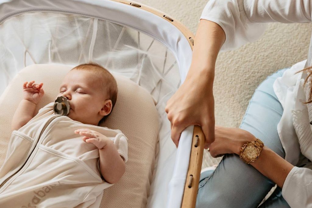 Baby in een Puckababy-slaapzak, liggend op een AeroSleep-matras