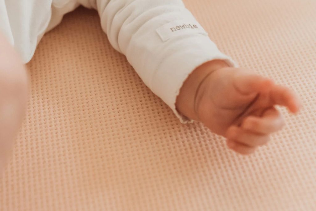 Baby op een matras met een geperforeerd hoeslaken