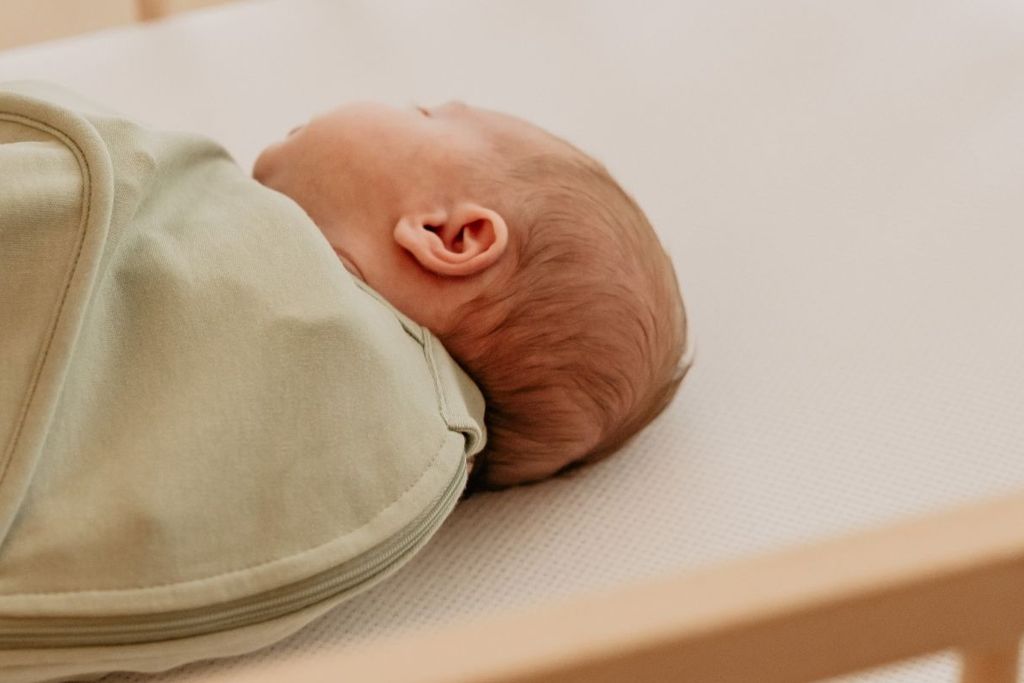 Een slapende baby ligt op een AeroSleep matras.