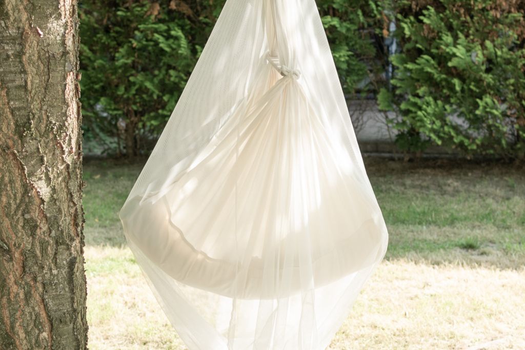 Ein Mosquitonetz net an einer Federwiege befestigt