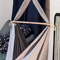 A gray hammock with focus on the wooden spreader bar