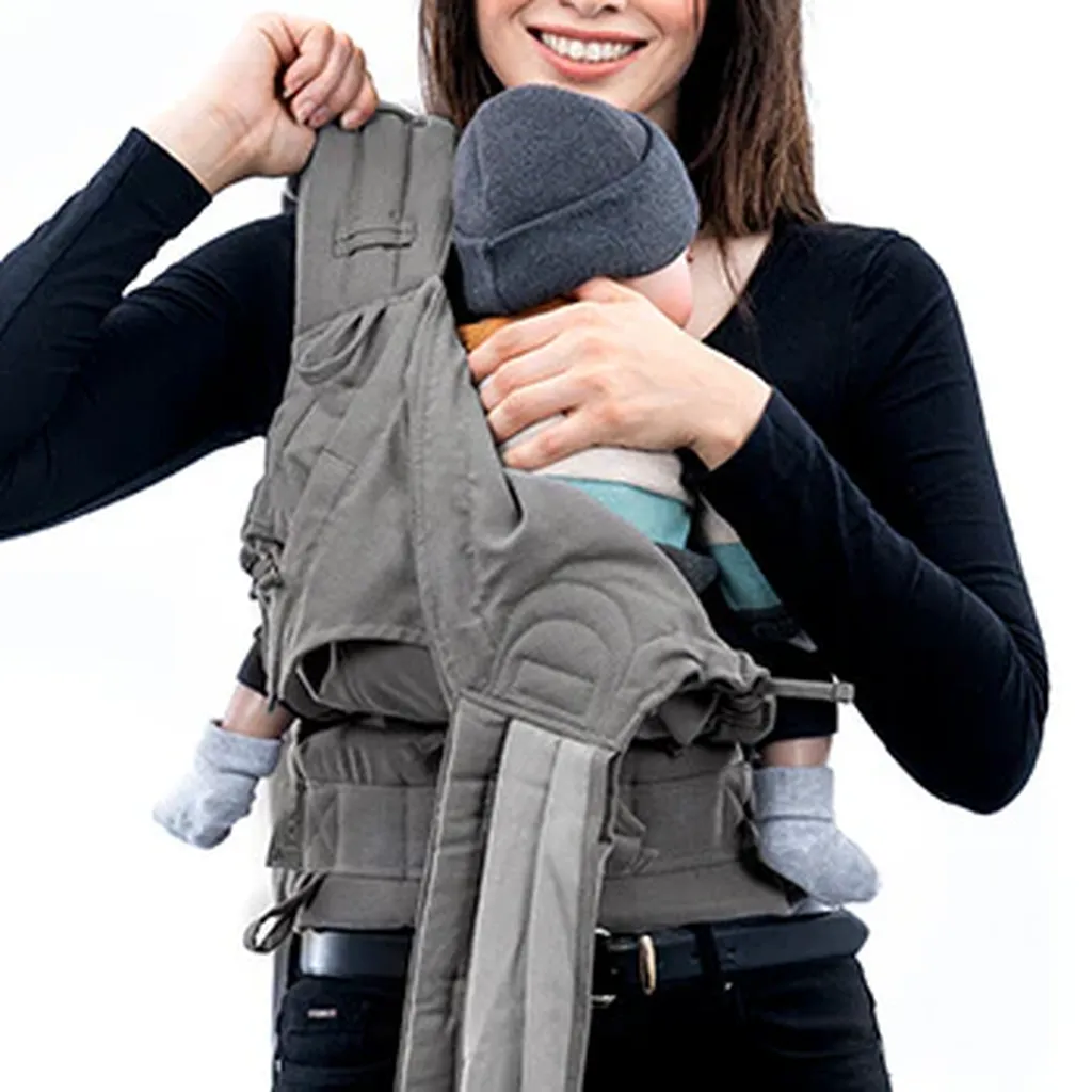 Femme mettant un bébé dans le porte-bébé