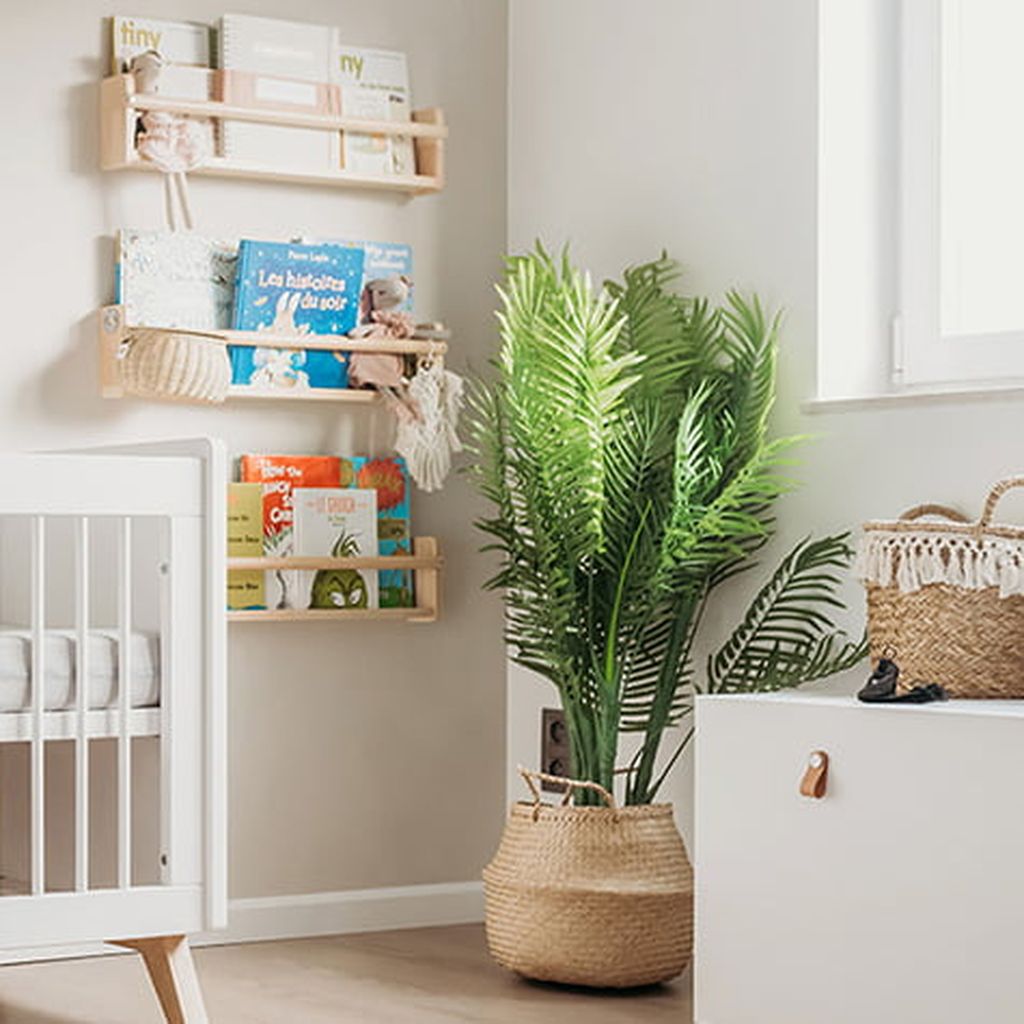 Eine gemütliche Kinderzimmer-Ecke mit einem Kinderbett, an der Wand befestigten Bücherregalen voller Kinderbücher