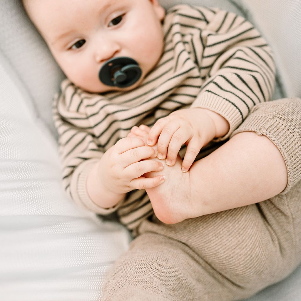 Baby schläft in einer grauen Federwiege