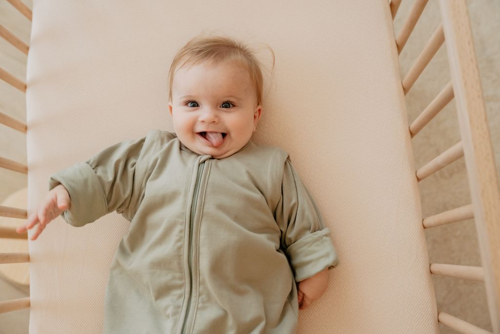 Smiling baby lying in a crib