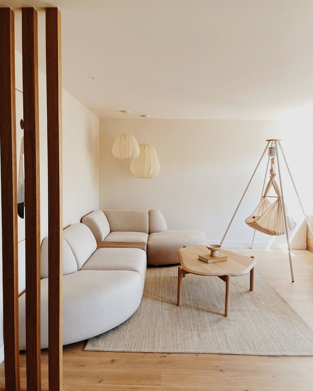 Minimalistisches Wohnzimmer mit einer Hängematte und einem weißen Tipi-Ständer mit Motor zum Aufstellen und Bewegen.
