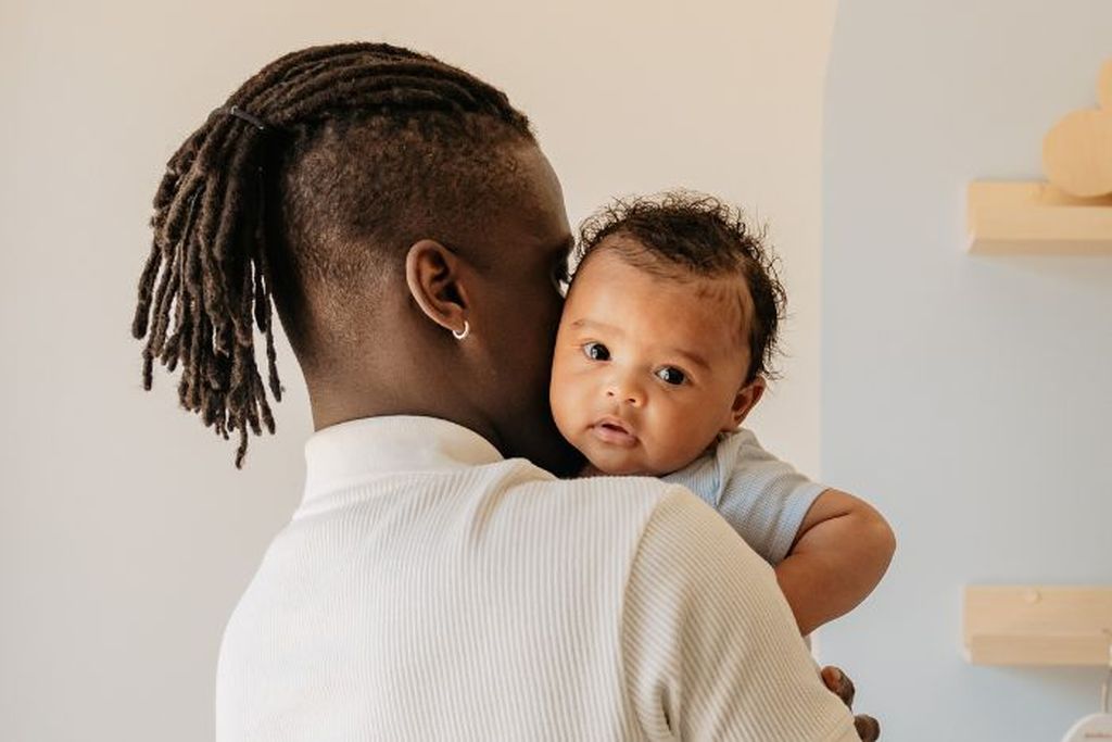 Vader die zijn baby vasthoudt