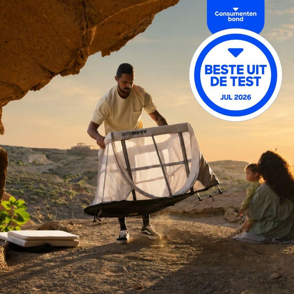 A man sets up a portable travel bed outdoors, with a woman and child sitting nearby. A "Best in Test" badge for July 2026 is displayed.