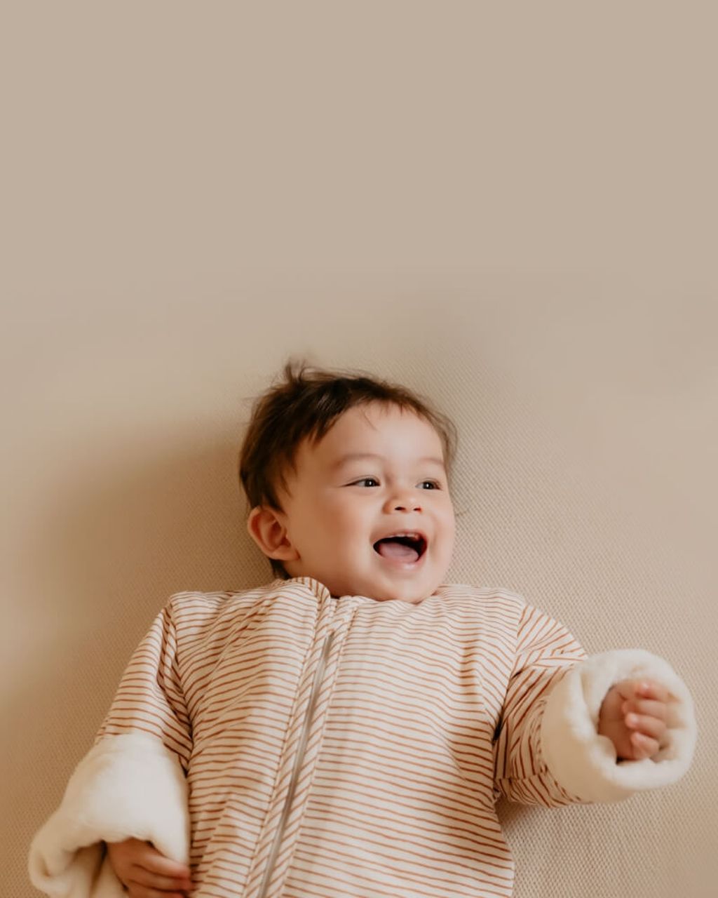 Un bébé tout sourire dans une gigoteuse d'hiver
