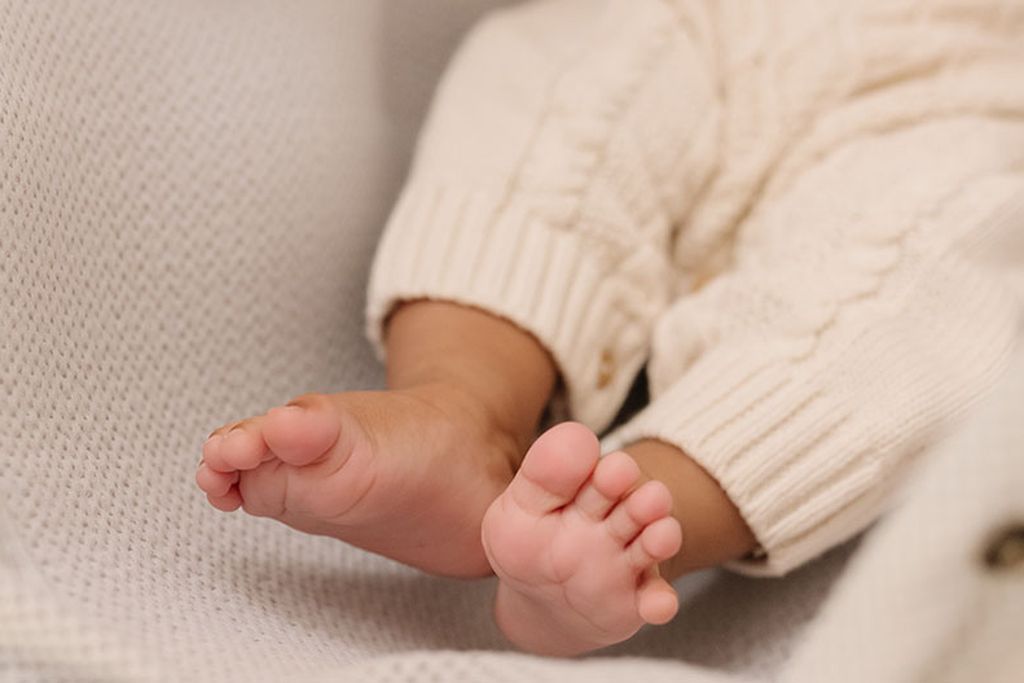 Nahaufnahme der Füße eines Babys, die auf dem 3D-Matratzenschoner ruhen