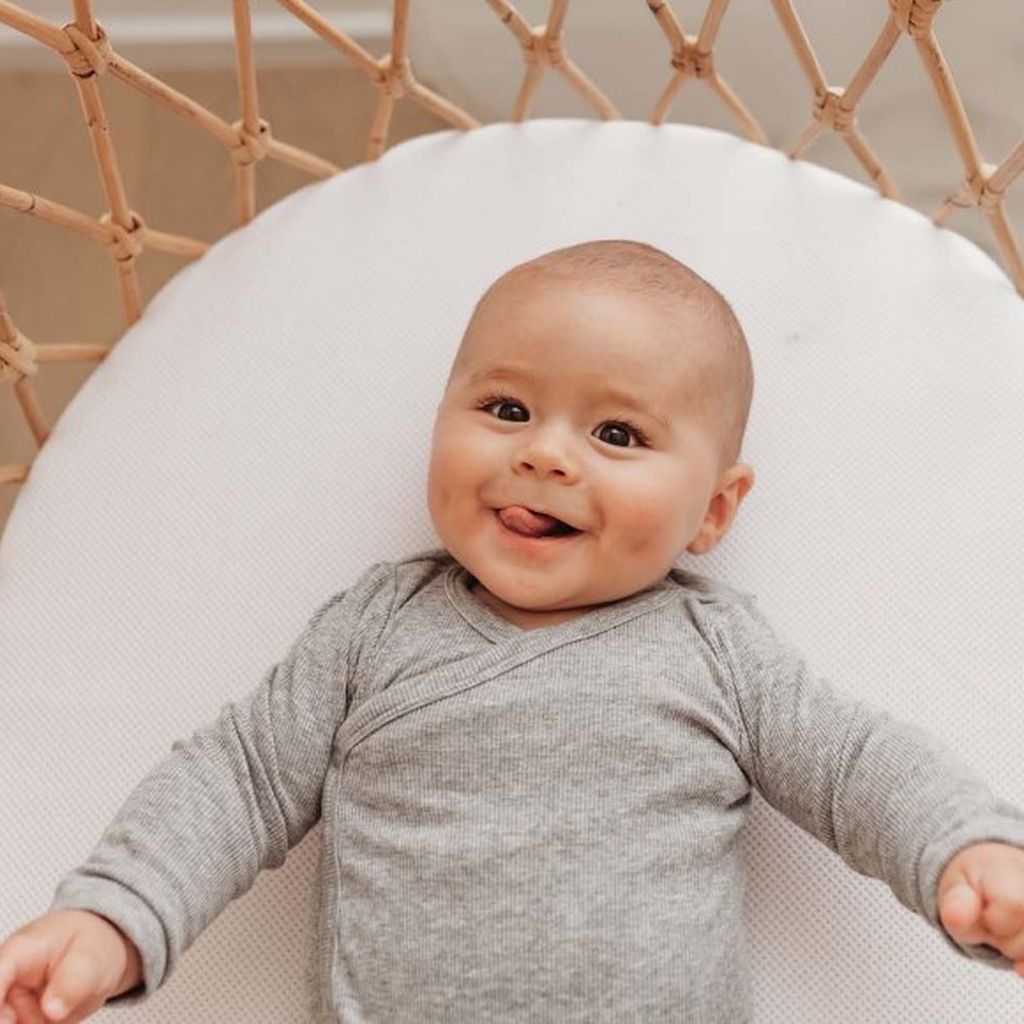 Baby liggend op een met AeroSleep-producten opgemaakt bedje.