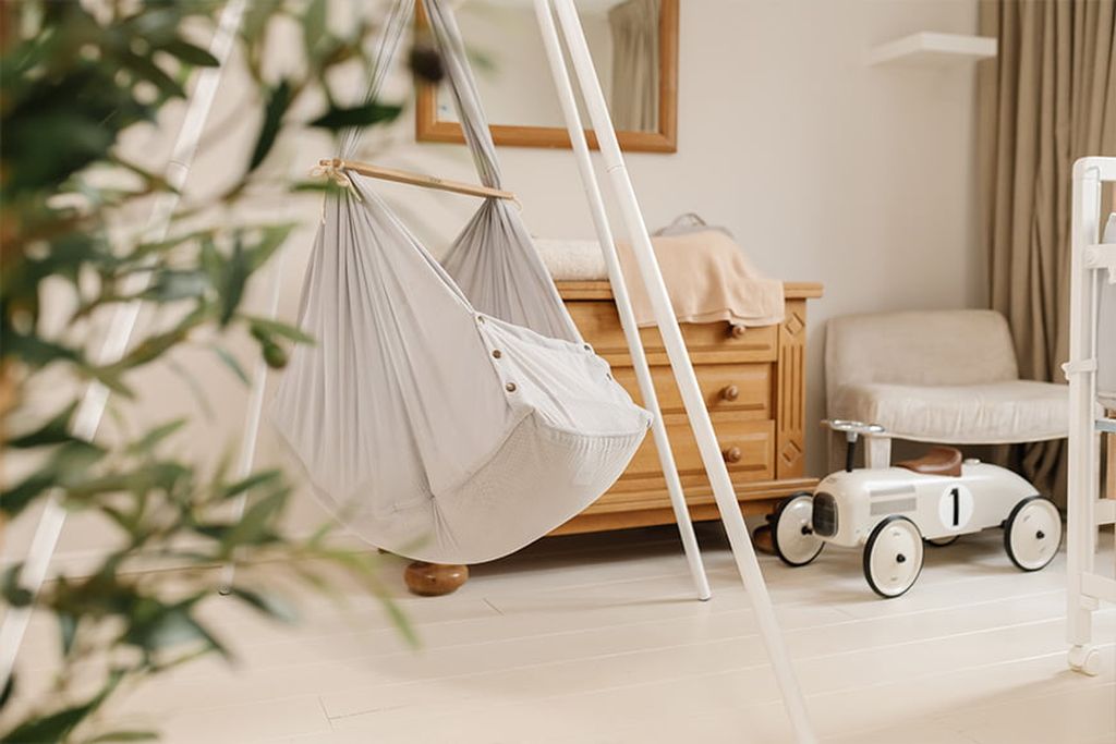 Federwiege, montiert auf einem Tipi-Gestell im Kinderzimmer