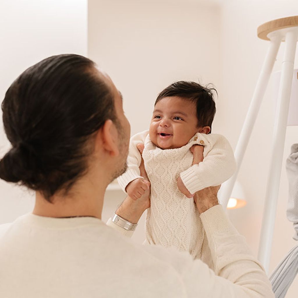 Das Baby wird im Arm gehalten. Im Hintergrund sieht man das NONOMO mit Tipi-Ständer und Move-Motor.