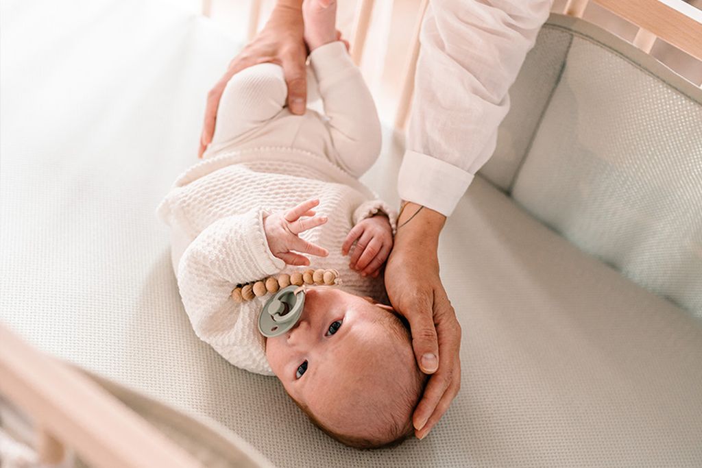 Babytje in een met AeroSleep-producten opgemaakt ledikant