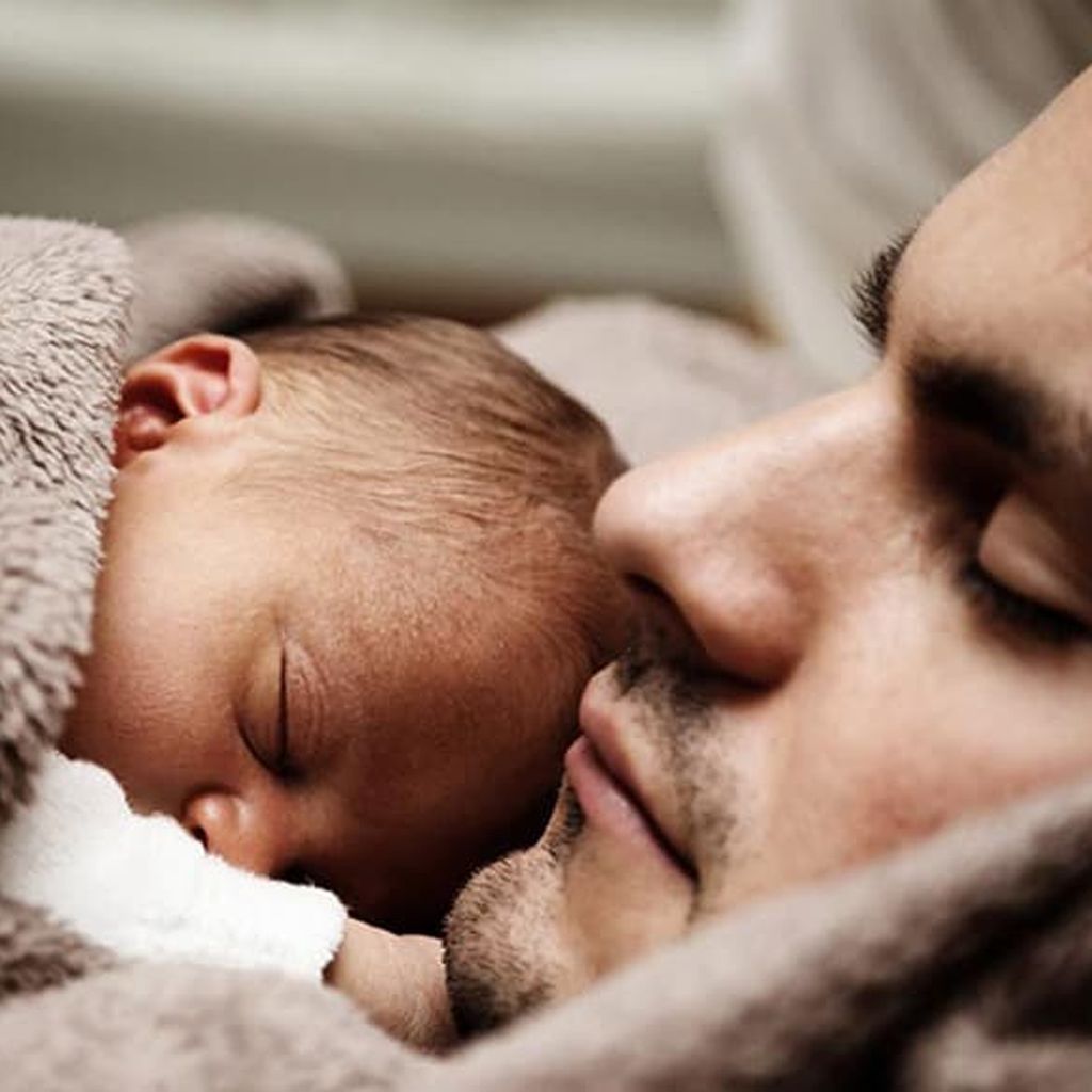 Baby kuschelt mit Papa