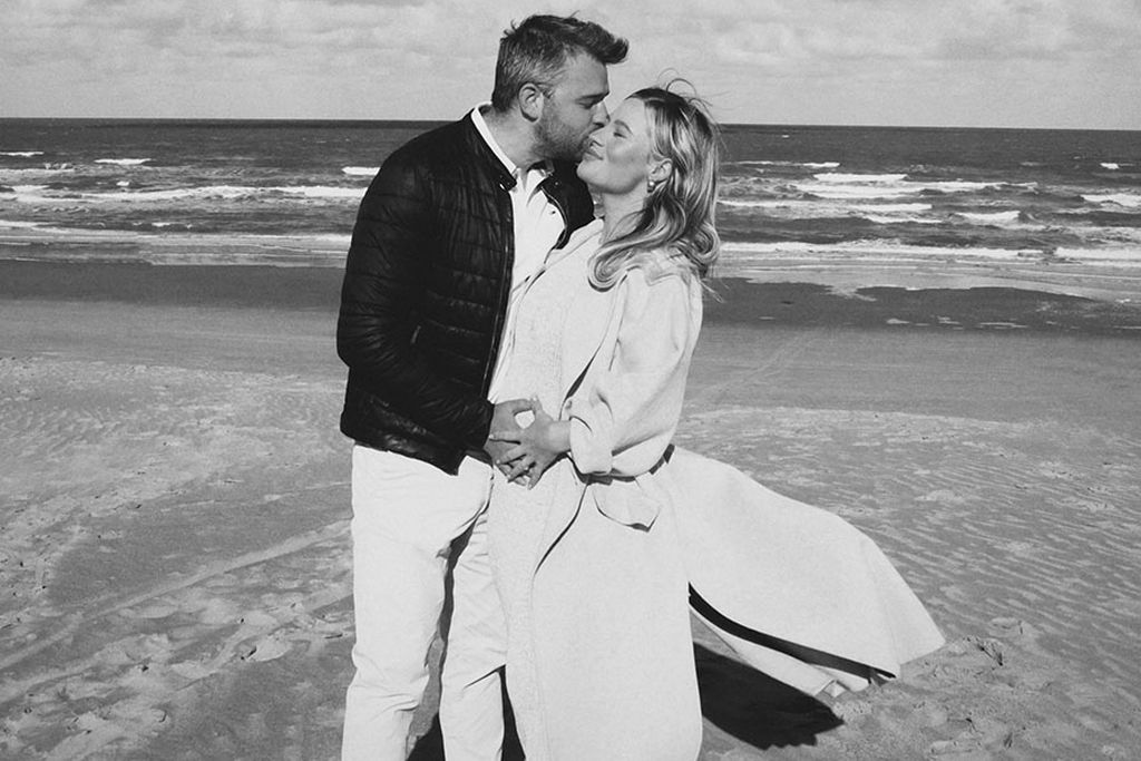 Schwarz-Weiß-Foto: Ein Paar steht an einem Strand, umarmt sich und lächelt