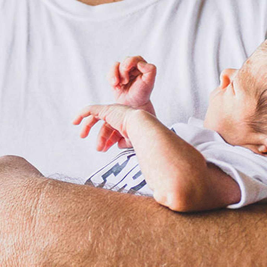 Das Baby wird liebevoll in den Armen eines Mannes getragen