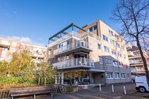 Appartementencomplex met 5 etages met een dubbele zitbank beneden op de stoep