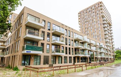 Moderne appartementencomplexen met balkons, met op de achtergrond een gebouw van meerdere verdiepingen.