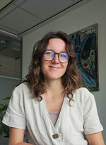 Een portretfoto van een jonge vrouw met bruin haar en een bril.