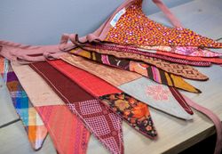 Een stoffen vlaggenlijn met verschillende rode prints die op een tafel ligt.