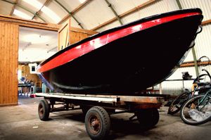 Een boot op een kar in een werkplaats.