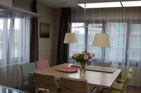 Eettafel met daarop een vaas met bloemen in gezamenlijke woonruimte