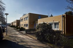 Woonwijk met lage woningen met kleine voortuinen afgeschermd met lage heggen