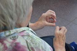 Twee vrouwenhanden die vervormd zijn door reuma van bovenaf gezien doen een beweegactiviteit