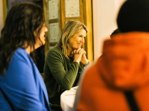 De koningin luistert in een geboeide houding naar het verhaal van een van de bewoners