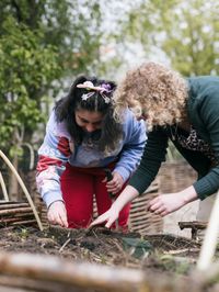 2 personen zijn aan het tuinieren in de moestuinbak