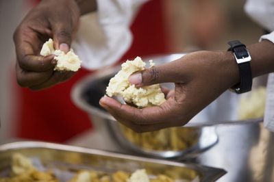 Iemand houdt balletjes deeg in zijn handen.