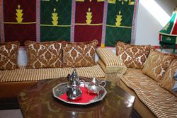 Hoekbank met salontafel en een zilverkleurige Marrokaanse thee set.