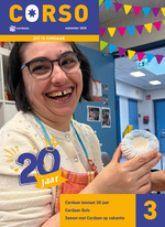 Een jonge dame met bril en brede glimlach laat een kandelaar van klei zien. Ze draagt een schort.