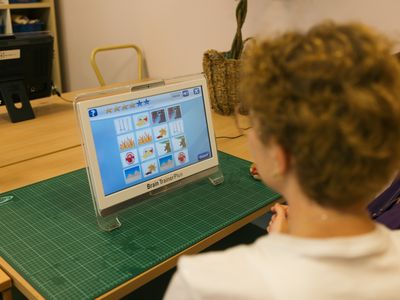 Over de schouder van een vrouw met blond kort haar zie je een computerscherm met 16 afbeeldingen. Er zijn 8 keer twee dezelfde afbeeldingen.