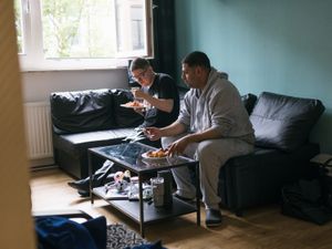 2 personen eten hun bord met eten samen op de bank