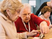 Twee oudere dames spelen samen Rummikub