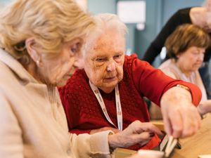 Twee oudere dames spelen samen Rummikub
