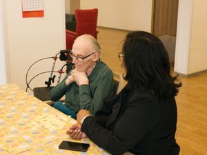 2 personen zitten aan tafel in gesprek
