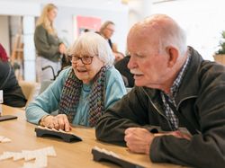 Oudere man en vrouw spelen samen Rummikub