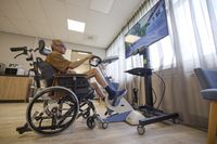 Een man fietst op een theravital en kijkt naar een route op het scherm