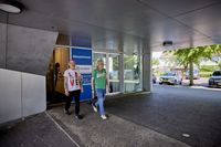 Even lekker erop uit om samen te wandelen. Twee lachende personen verlaten de hoofdingang van Geuzenhoek en hebben er flink de pas in.