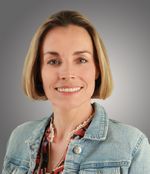 Een vrouw met een blonde boblijn kijkt vriendelijk in de camera.