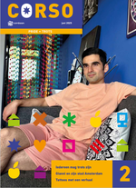 Een man zit op een bank in een donkerblauwe woonkamer en kijkt trots.