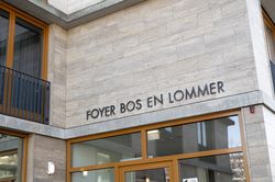 Deel van een gebouw van lichte steen. Boven de deur staat Foyer Bos en Lommer