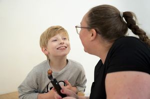 Kind en begeleider lachen tijdens het eten