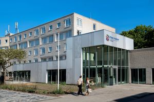 Modern, strak en licht gebouw. Vier hoog en grote ramen bij de ingang.