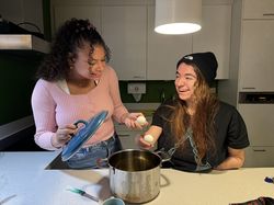 Twee personen staan aan het aanrecht. Ze hebben allebei een ei in hun hand. Op het aanrecht staat een pan. De linkerpersoon heeft de deksel in haar hand.