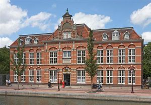 Groot rood bakstenen gebouw met veel ramen.