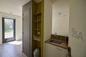 Keukenblok in een woning met een gootsteen een magnetron en een kast met opbergruimte.